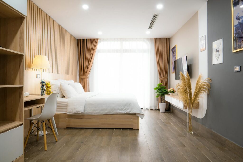 Habitación interior con cama matrimonial, suelo de madera laminada e iluminación cálida