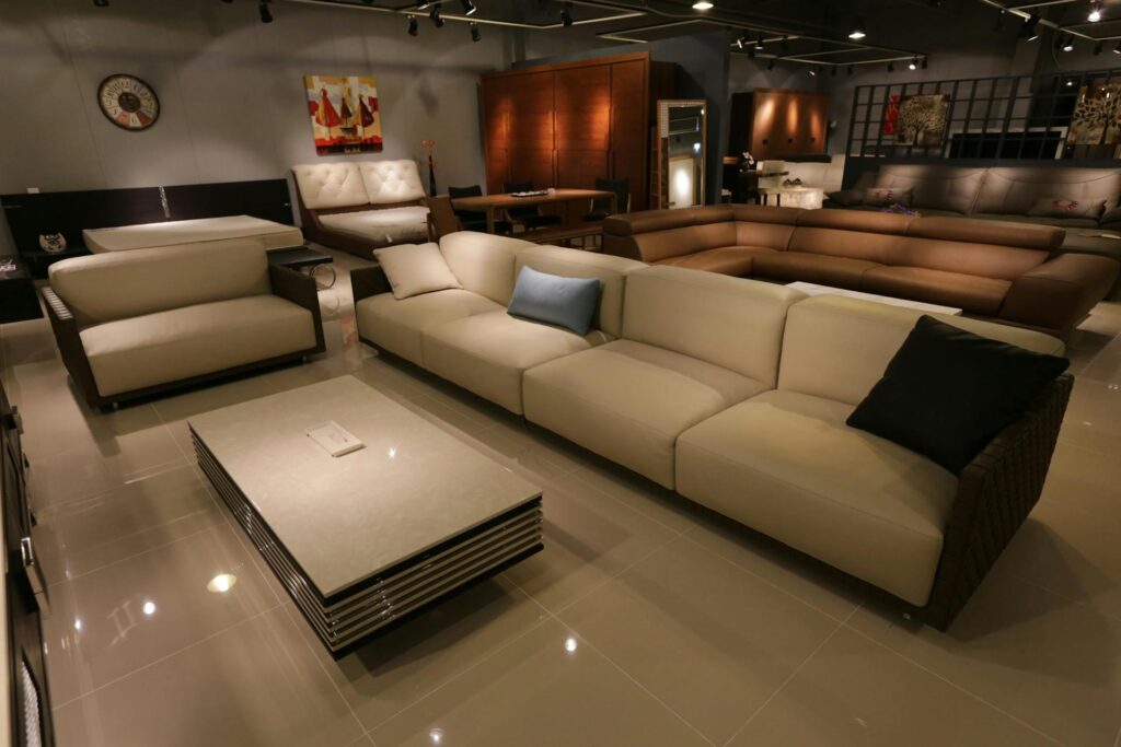 Sala de exhibición de muebles con sofás de color beige y mesa de centro moderna de vidrio