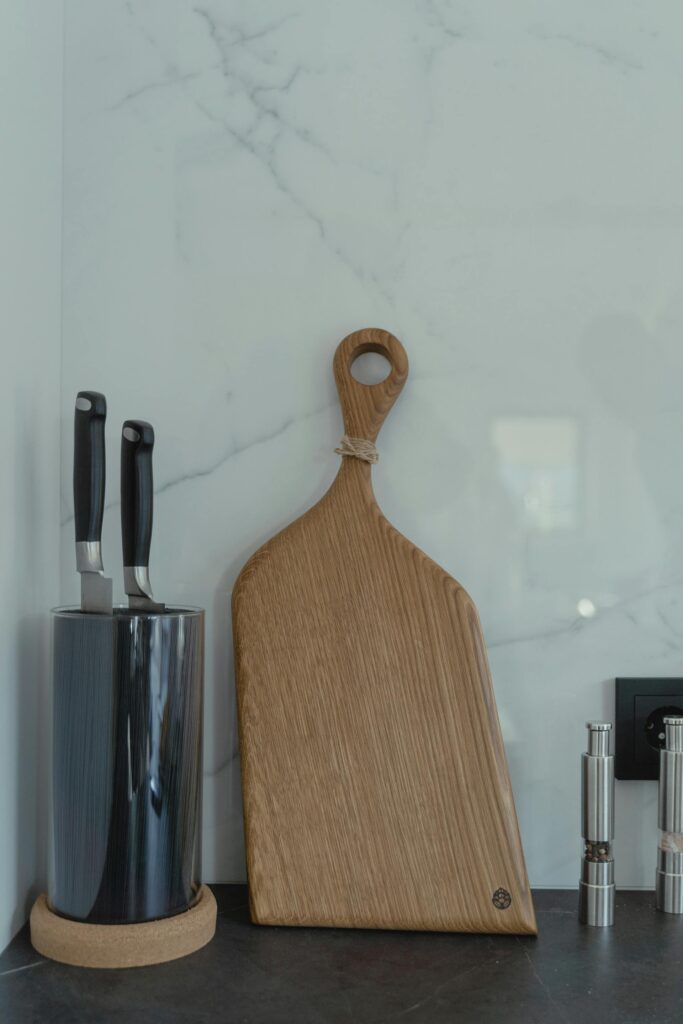 Tabla de cortar de madera con mango y cuchillos de cocina