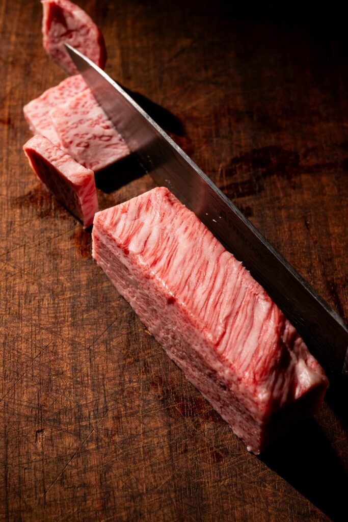 Corte transversal de pieza grande de carne de res fresca sobre tabla de madera