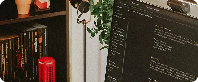 Librero con tomos de libros, computadora donde se muestra contenido