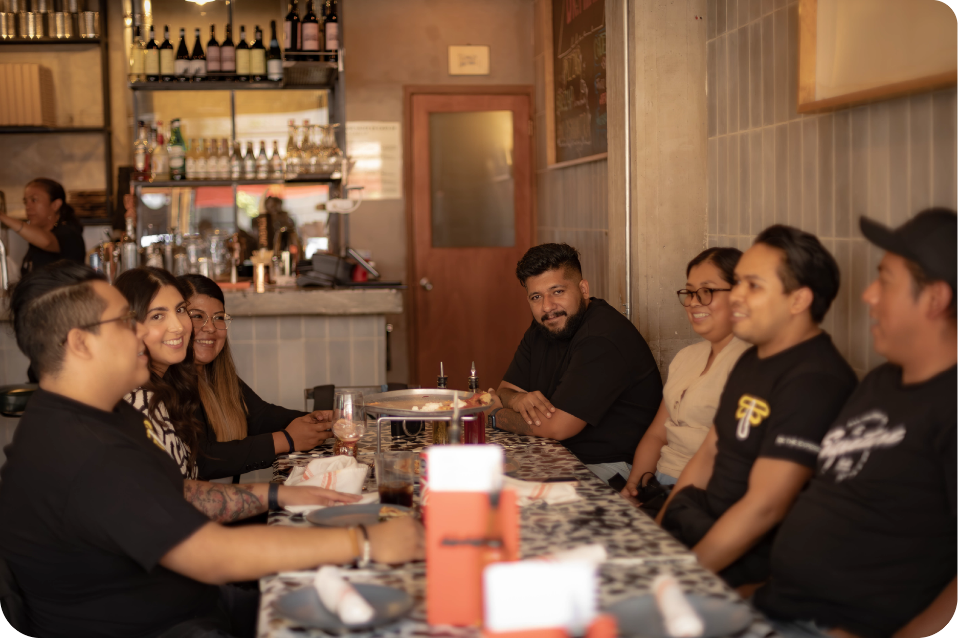 Equipo de trabajo compartiendo un momento de integración durante una comida fuera de la oficina.