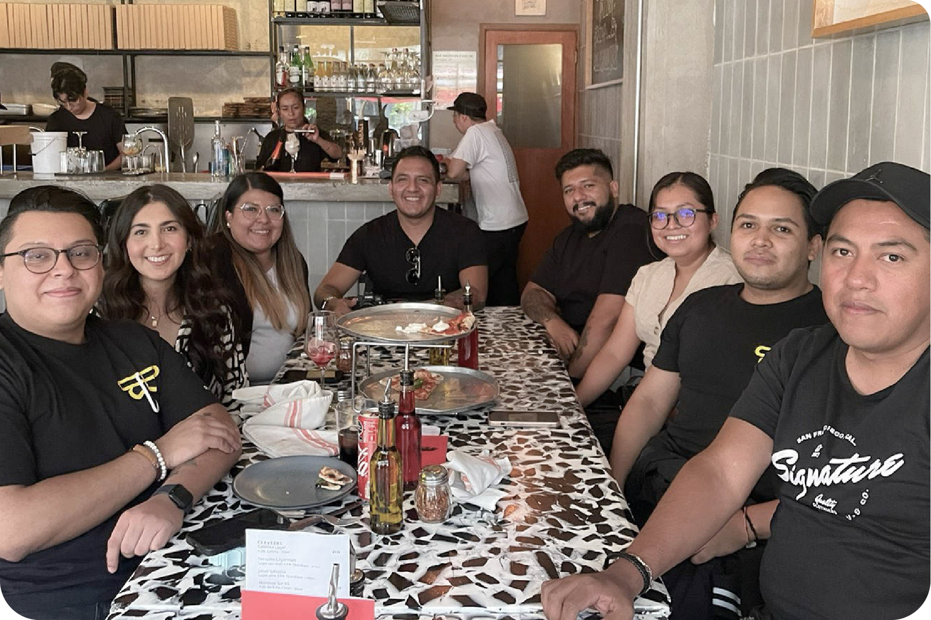 Equipo de trabajo compartiendo un momento de integración durante una comida fuera de la oficina.