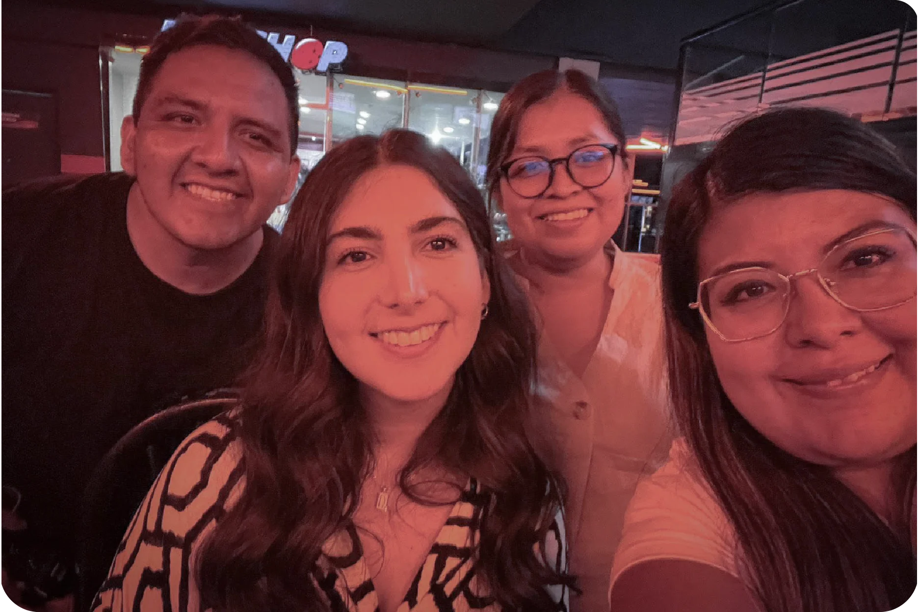 Foto grupal del equipo de trabajo celebrando y divirtiéndose durante una noche de integración en el boliche.