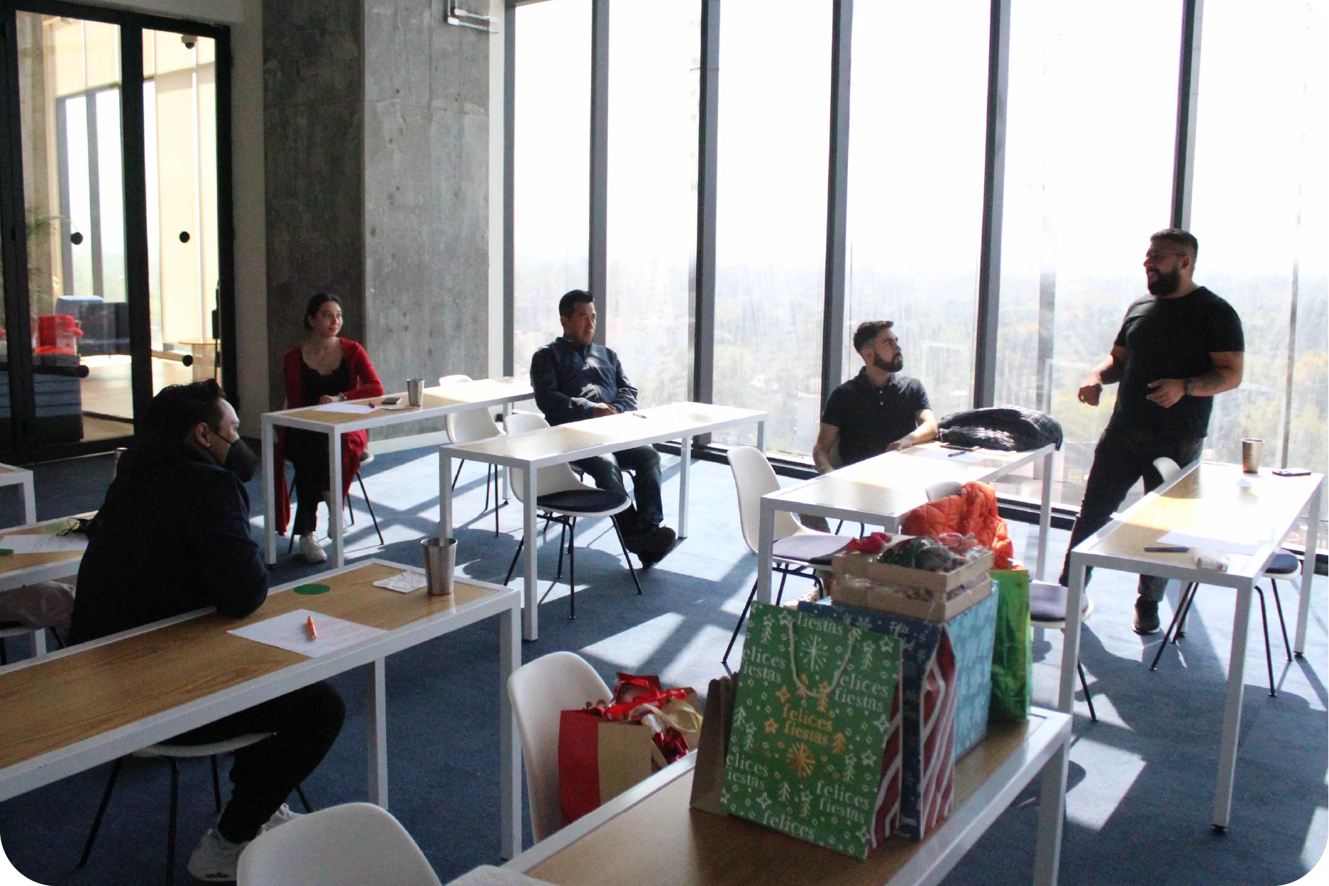Sesión de capacitación interna donde un miembro del equipo comparte ideas con sus compañeros en un ambiente de aprendizaje colaborativo.